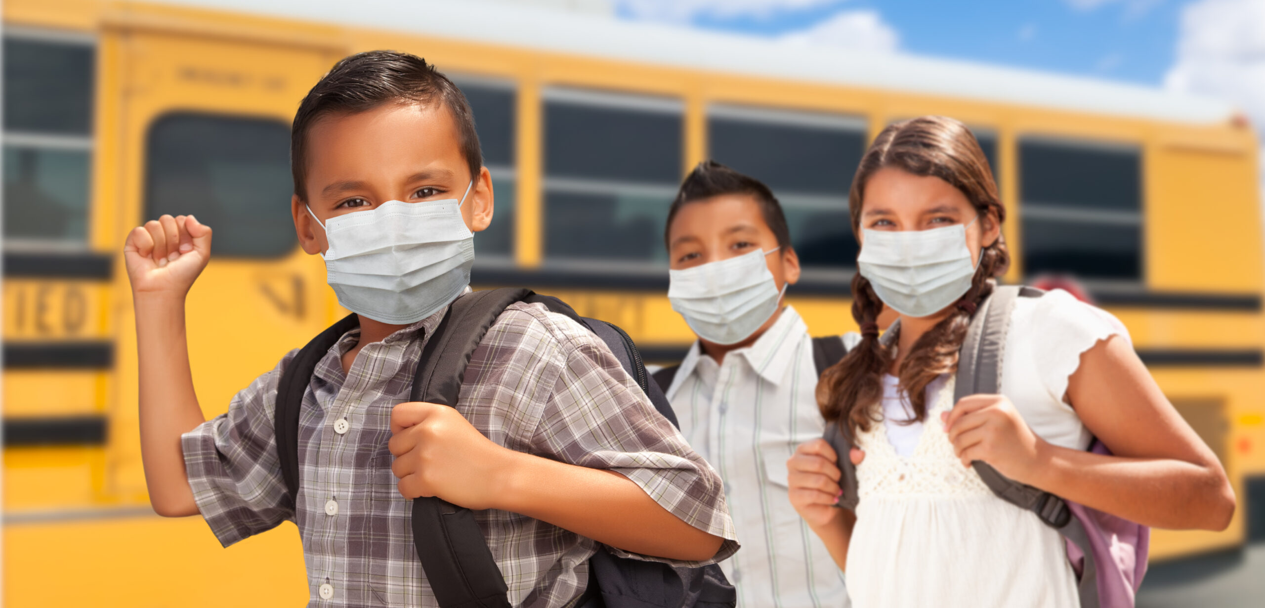 kids in masks boarding a school bus