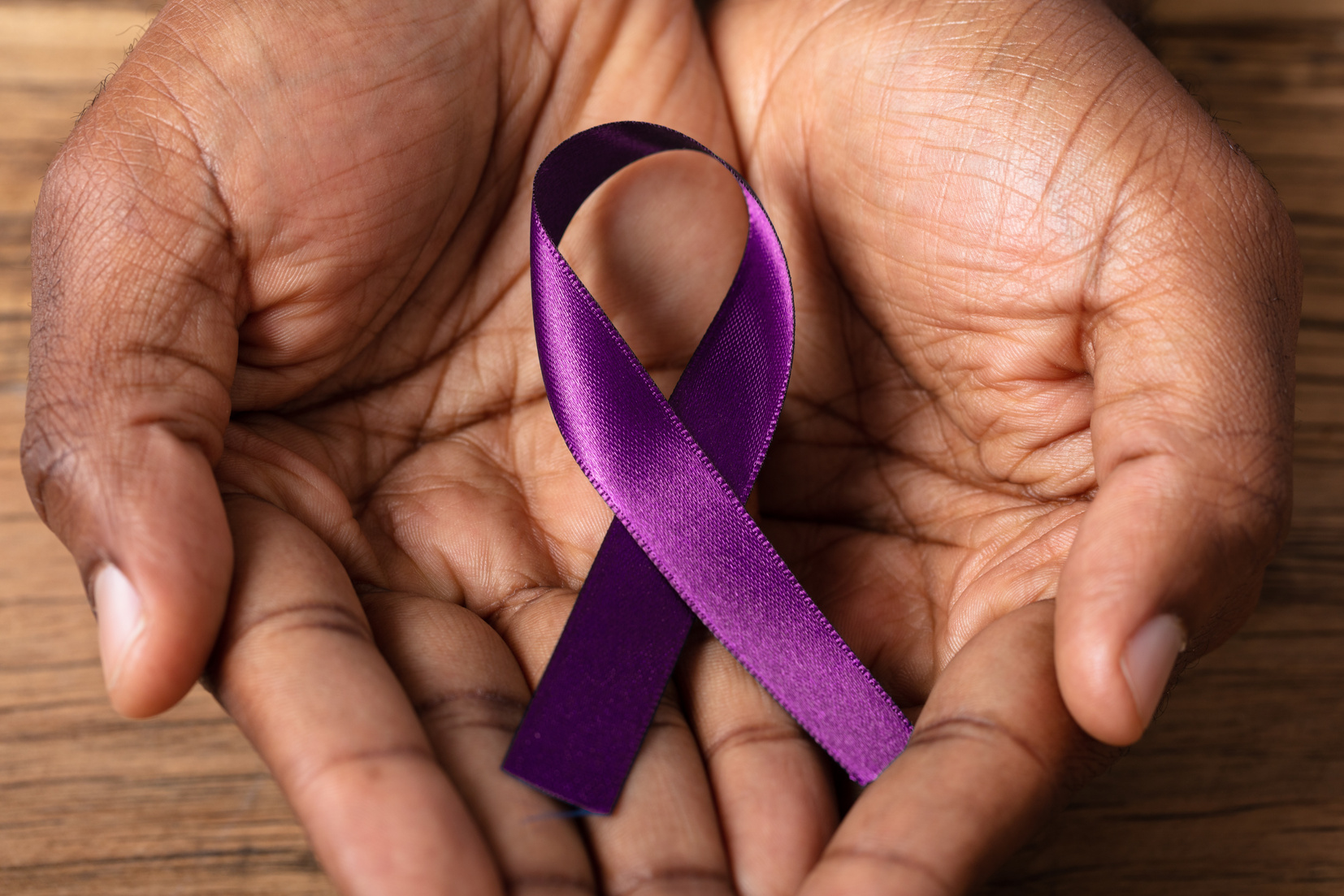 hands with a purple ribbon